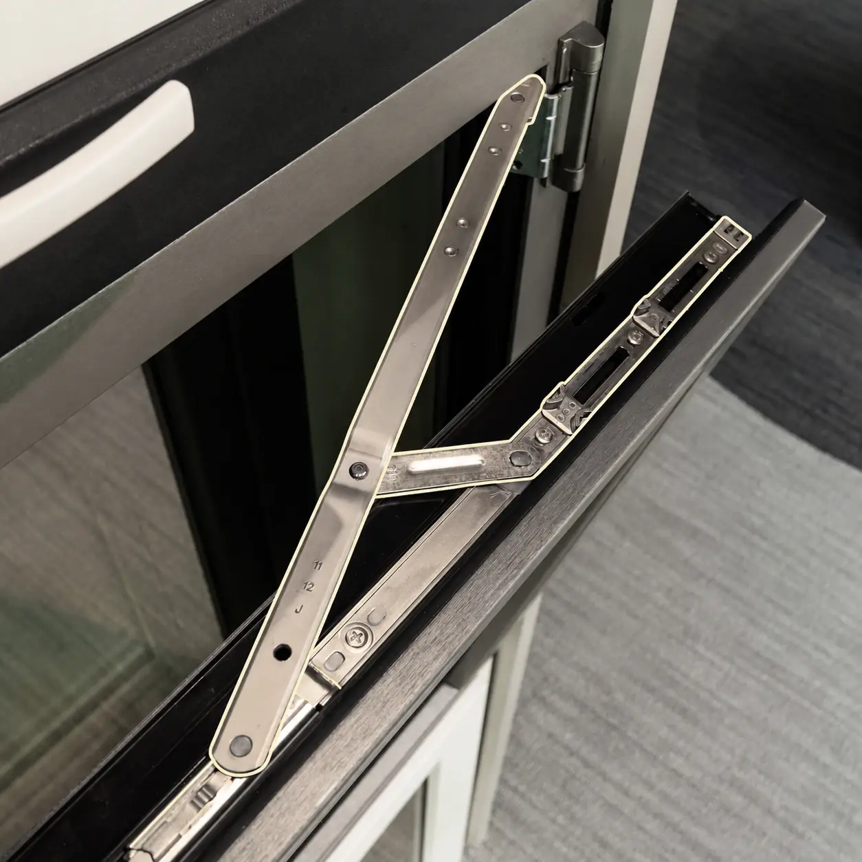 Detalle de herrajes de una ventana oscilobatiente Fentexhaus
