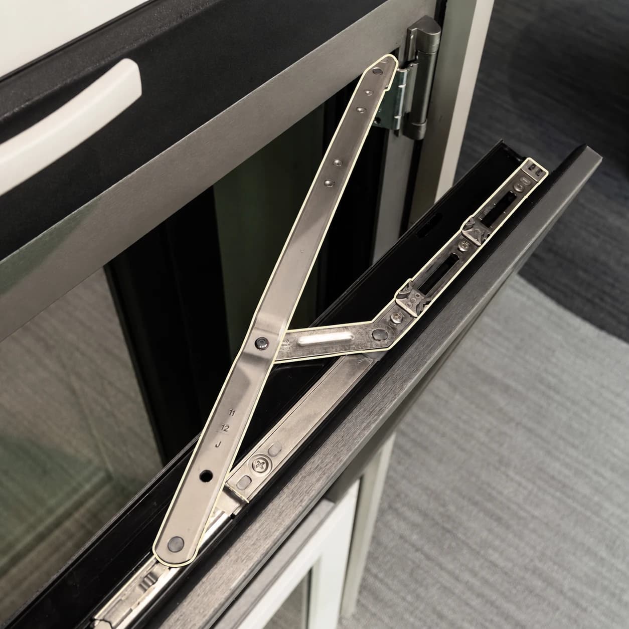 Detalle de herrajes de una ventana oscilobatiente Fentexhaus