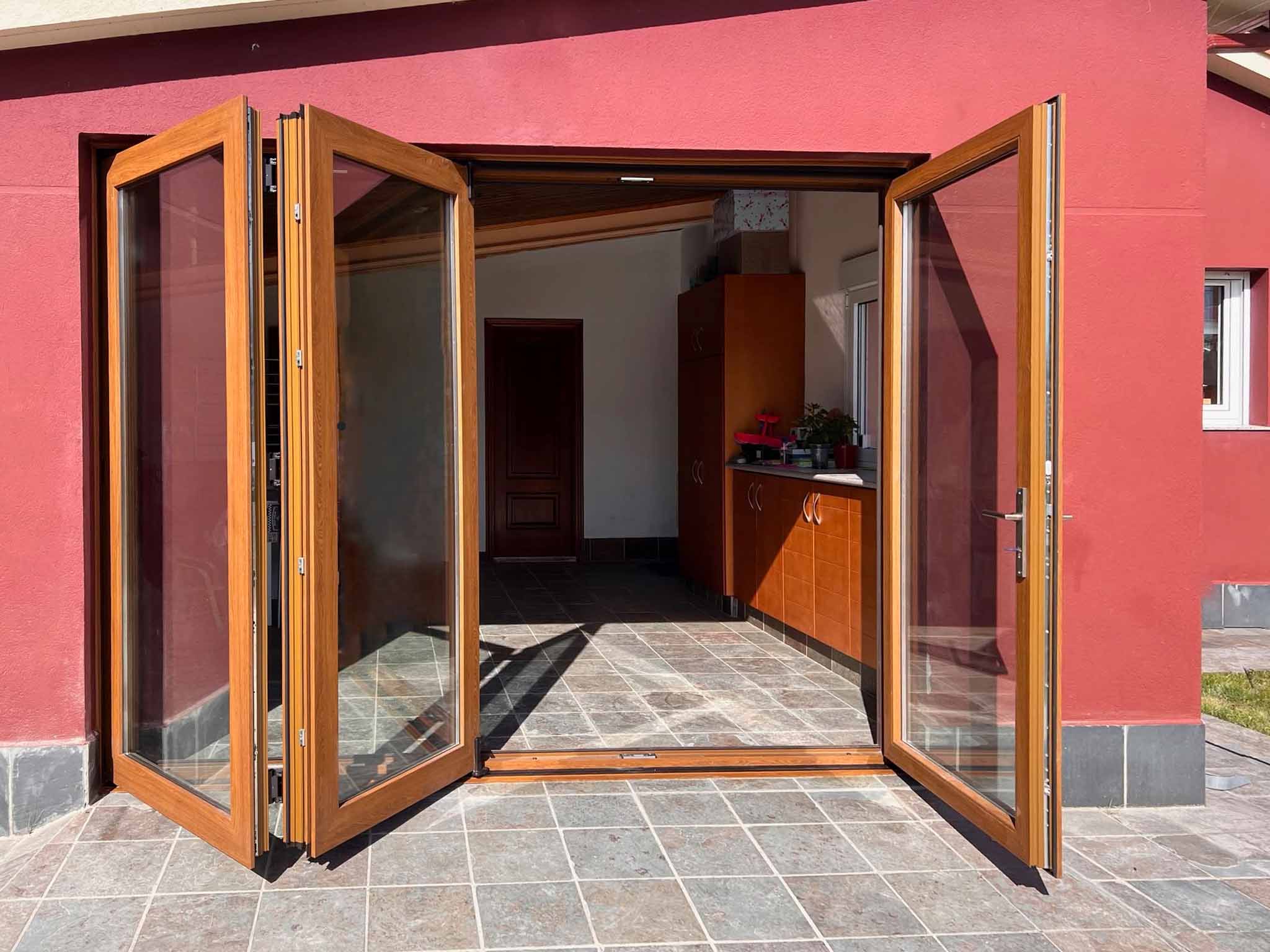 Puerta plegable Kömmerling con acabado madera